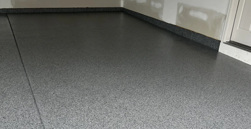 Dark grey flake epoxy garage floor with matching cove base in a Berks County home