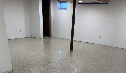 Tan flake epoxy basement floor laid around a steel support post in an older Pennsylvania house
